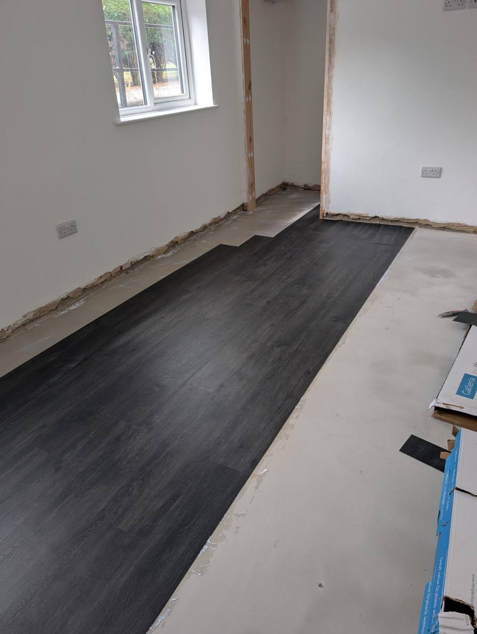 Dark grey oak-effect LVT planks being laid