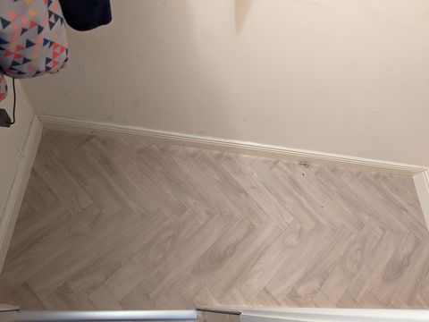 Herringbone-effect vinyl laid to the skirting