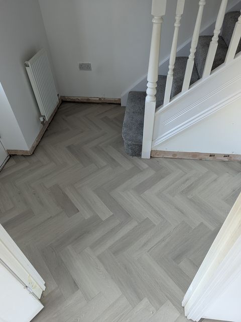 Light grey herringbone LVT, hallway by the stairs