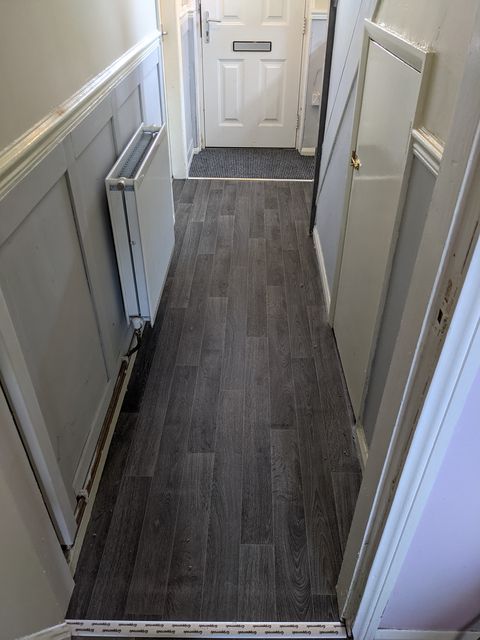 Dark wood-effect vinyl hallway with entrance matting